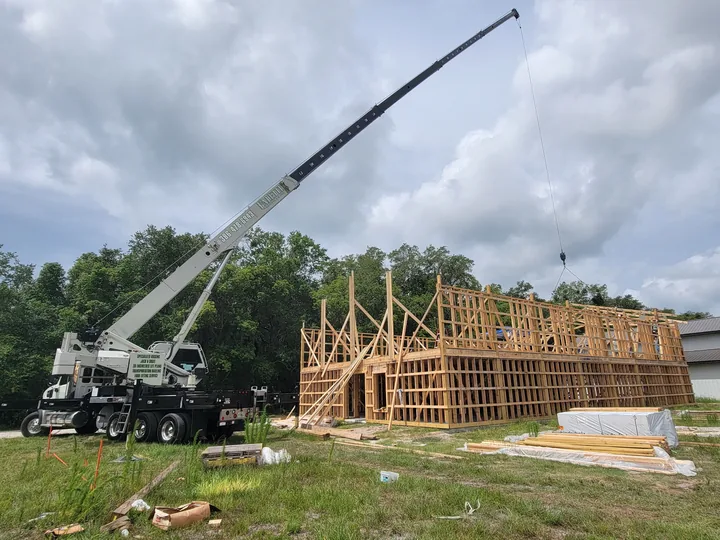 White crane beside timber building framing.